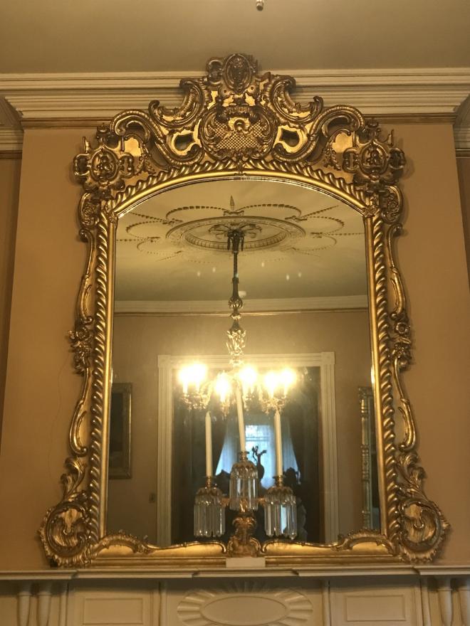 American Rococo Revival, carved gesso and gilt framed mirror.  Human head at top looking down