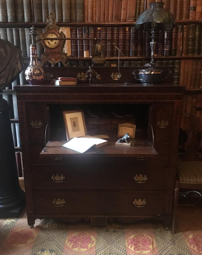 This American Federal drop panel mahogany desk has three small drawers on top, three large drawers at the bottom, a key cupboard on the right side, and a drawer of same size on the left with brass drawer pulls.