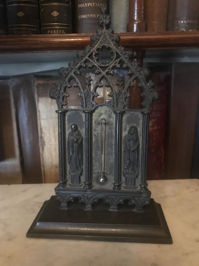 This table top bronze thermometer has two two saints under intricate Gothic arches