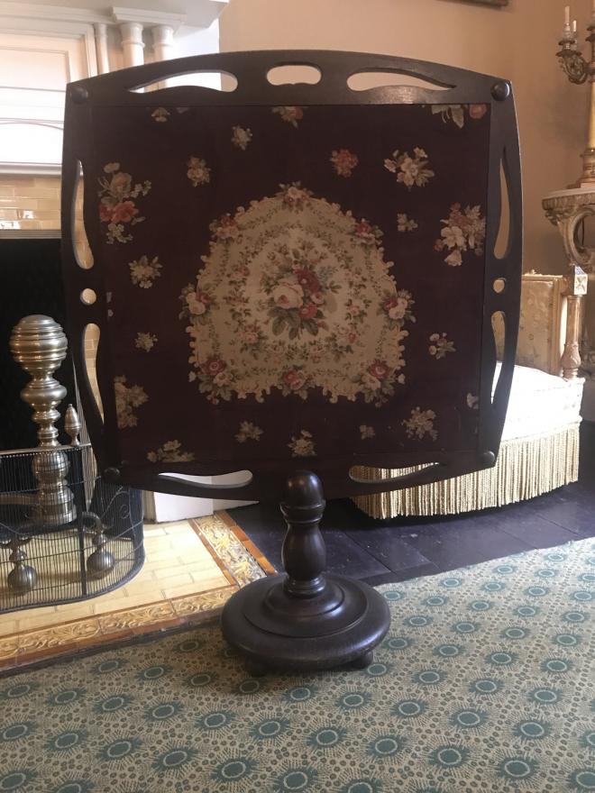Mahogany or walnut pierced frame with cloth screen - one side red and the other floral pattern.  Standard is short with round ball, slightly turned and round base set on four ball feet.