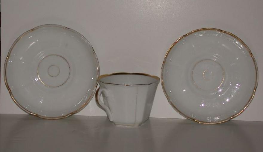 One large, white china cup and  two saucers.  Scalloped edges on both cups and saucers with gold rings.  Bottom of cup: "Rees."