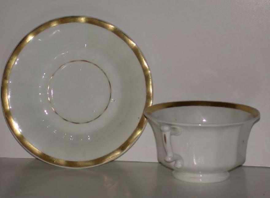 Four cups and  five saucers, large size, trimmed in gold.  Smooth outer edges.  Handles on cups are angular.