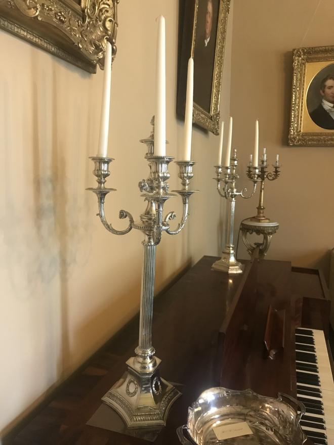 silver plated candleabra with three candle holders and  center with candle snuffer.  Fluted stem with six sided base.   Decorated with ram heads and garlands. 