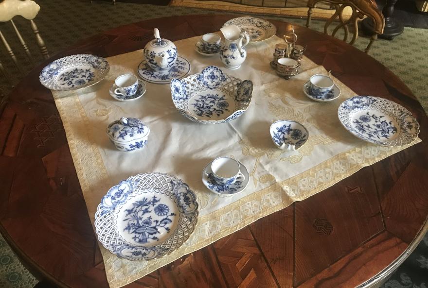 Meissen, blue and white porcelain tea set is in the  "Vienna Woods" style. The set  includes:  reticulated fruit dish, six fruit plates, 4 demitasses and saucers, small teapot, cream pitcher, milk pitcher, two shallow leaf shaped bowls,  shell dish, (1 3/4" diameter base) lobed box with cover.