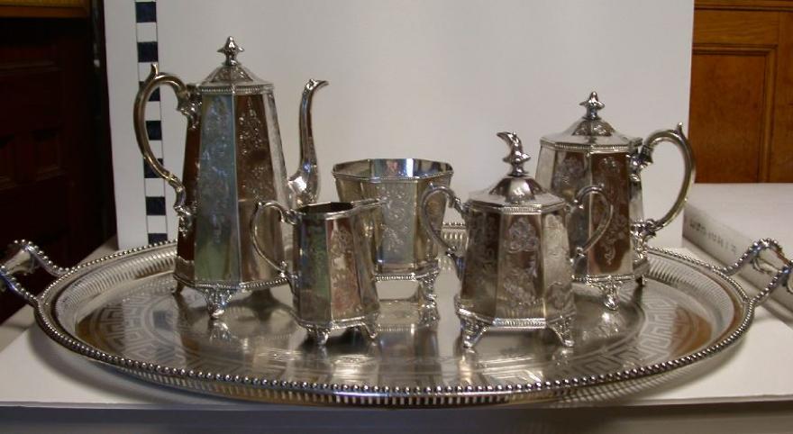 six piece silver tea set Includes a creamer, sugar bowl with separate top, slop jar, tea pot, coffee pot, and oval tray with two handles