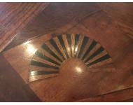 inlaid design in shape of fan with dark and light wood alternating