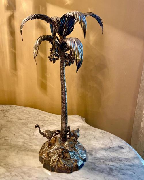  silver plated palm tree epergne. base with palm tree, two emus, one long palm frond, three branches with clusters of coconuts, one small piece with three coconuts, and two palm leaves clusters. 